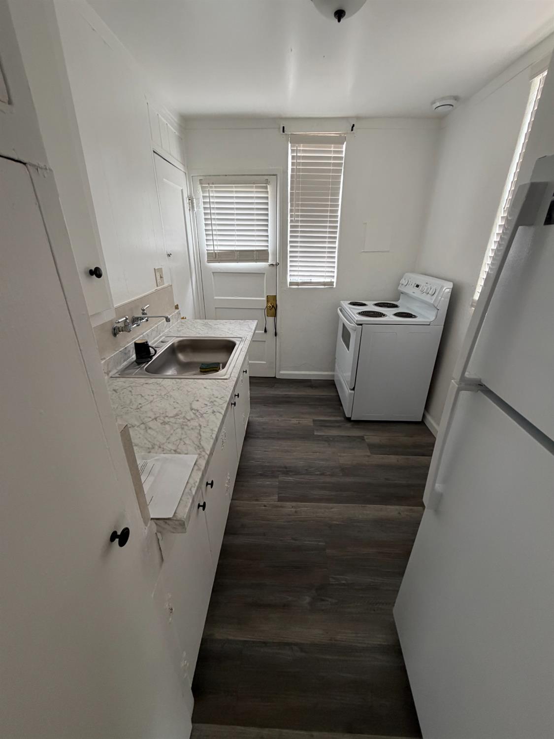 607 East Marshall Street Turlock, CA 95380 - Photo 6 of 9 a kitchen with granite countertop a sink and a stove top oven