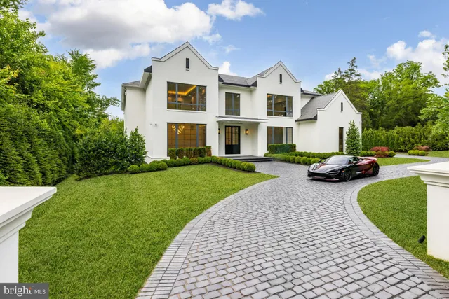 a front view of a house with a garden and trees