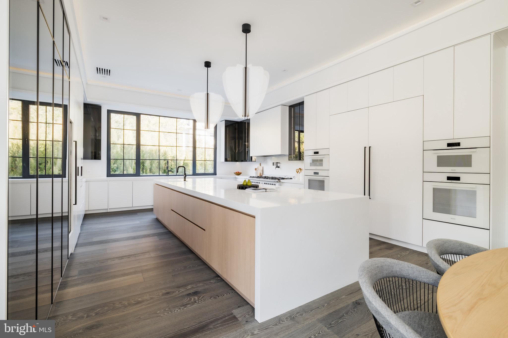 1102 Chain Bridge Road McLean, VA 22101 - Photo 17 of 50 a kitchen with kitchen island granite countertop a sink stove and wooden floor