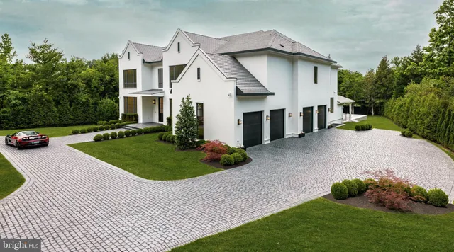 a white house with a small yard and a large parking space