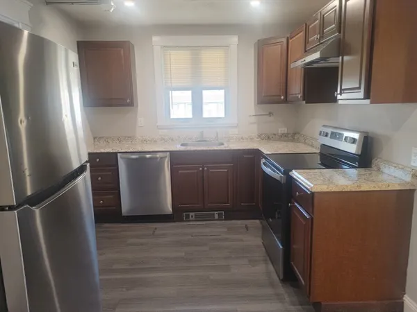 a kitchen with stainless steel appliances granite countertop a sink stove and refrigerator
