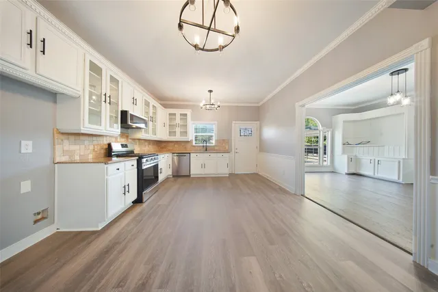 a white kitchen with a stove top oven sink and cabinets