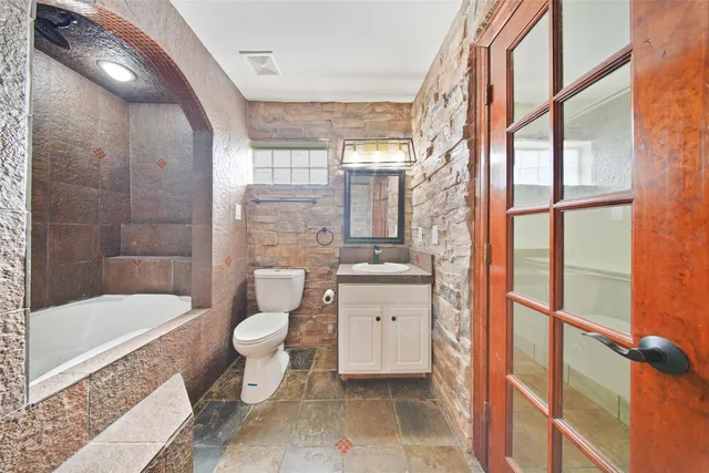 a bathroom with a double vanity sink toilet and shower