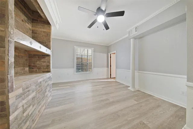 a view of an empty room with a window and wooden floor
