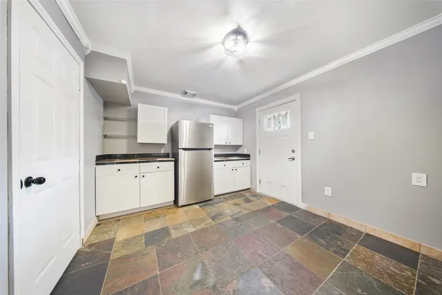 a kitchen with white cabinets and appliances