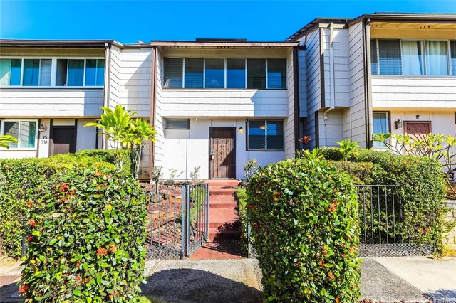 a front view of a house with a garden