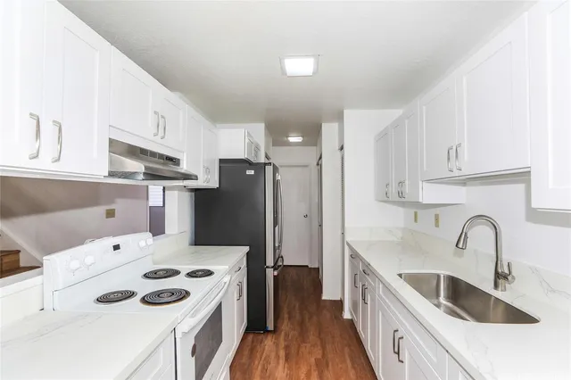 a kitchen with stainless steel appliances kitchen island a sink a refrigerator and cabinets