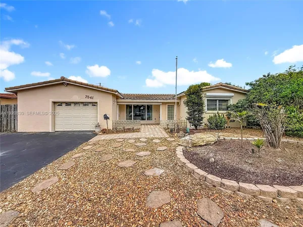 a view of a house with a patio and a yard