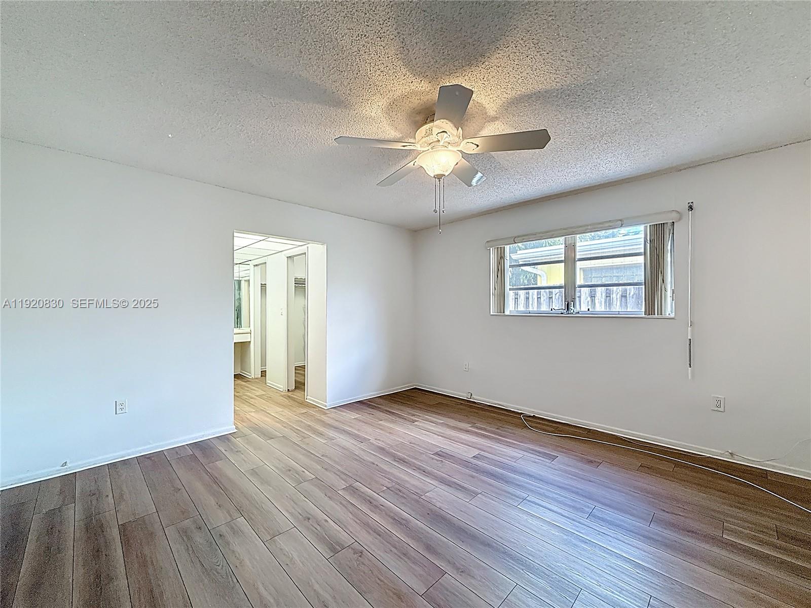 7541 Embassy Boulevard Miramar, FL 33023 - Photo 23 of 60 a view of an empty room with wooden floor and a window