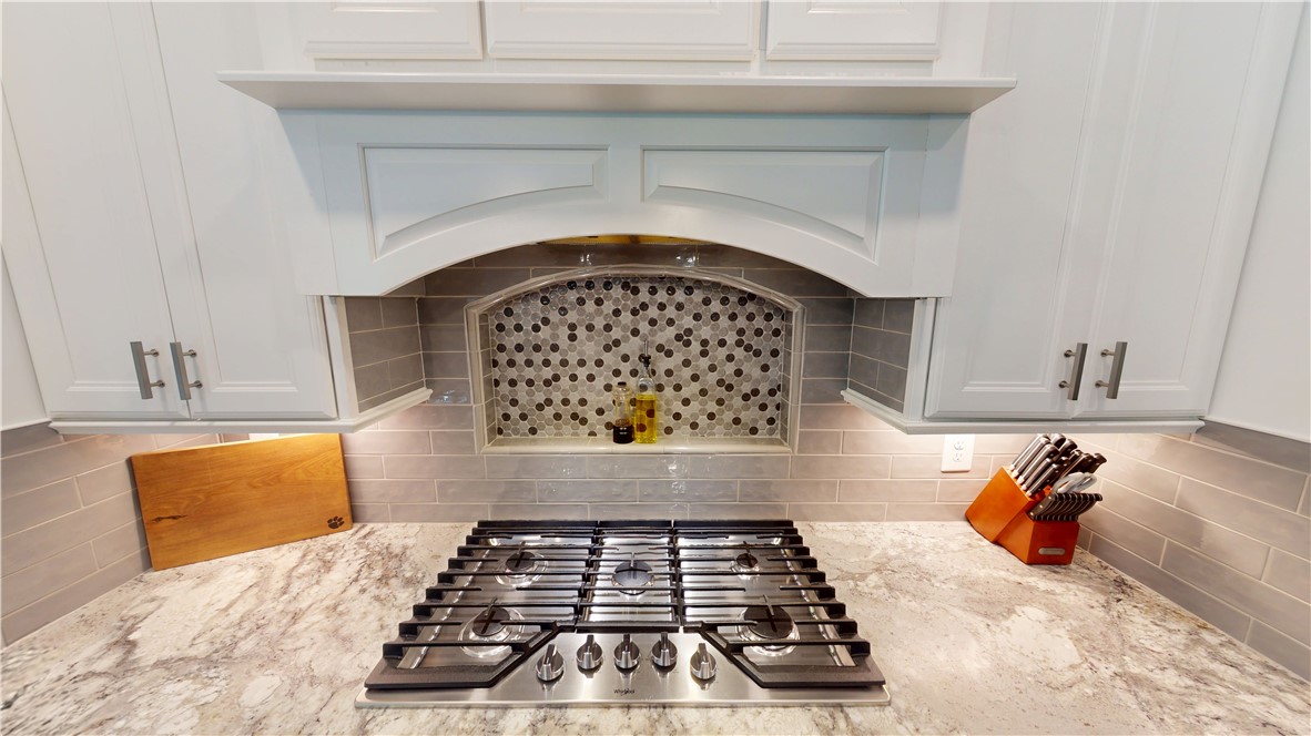 117 Shadowood Road Clemson, SC 29631 - Photo 12 of 45 Custom cabinetry and a decorative tile backsplash frame the professional gas cooktop.