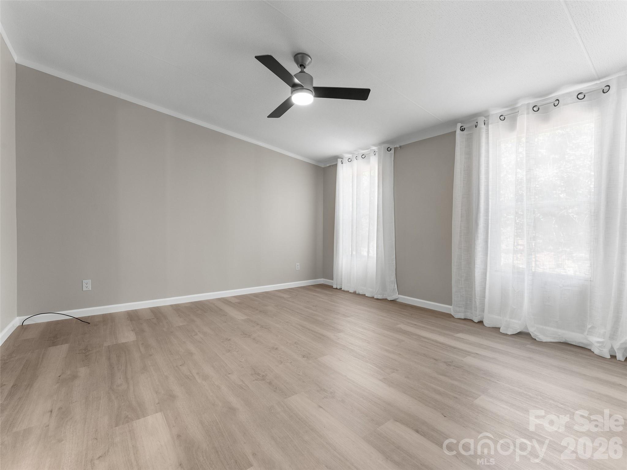 25 Overbrook Drive Saluda, NC 28773 - Photo 19 of 42 an empty room with wooden floor ceiling fan and windows