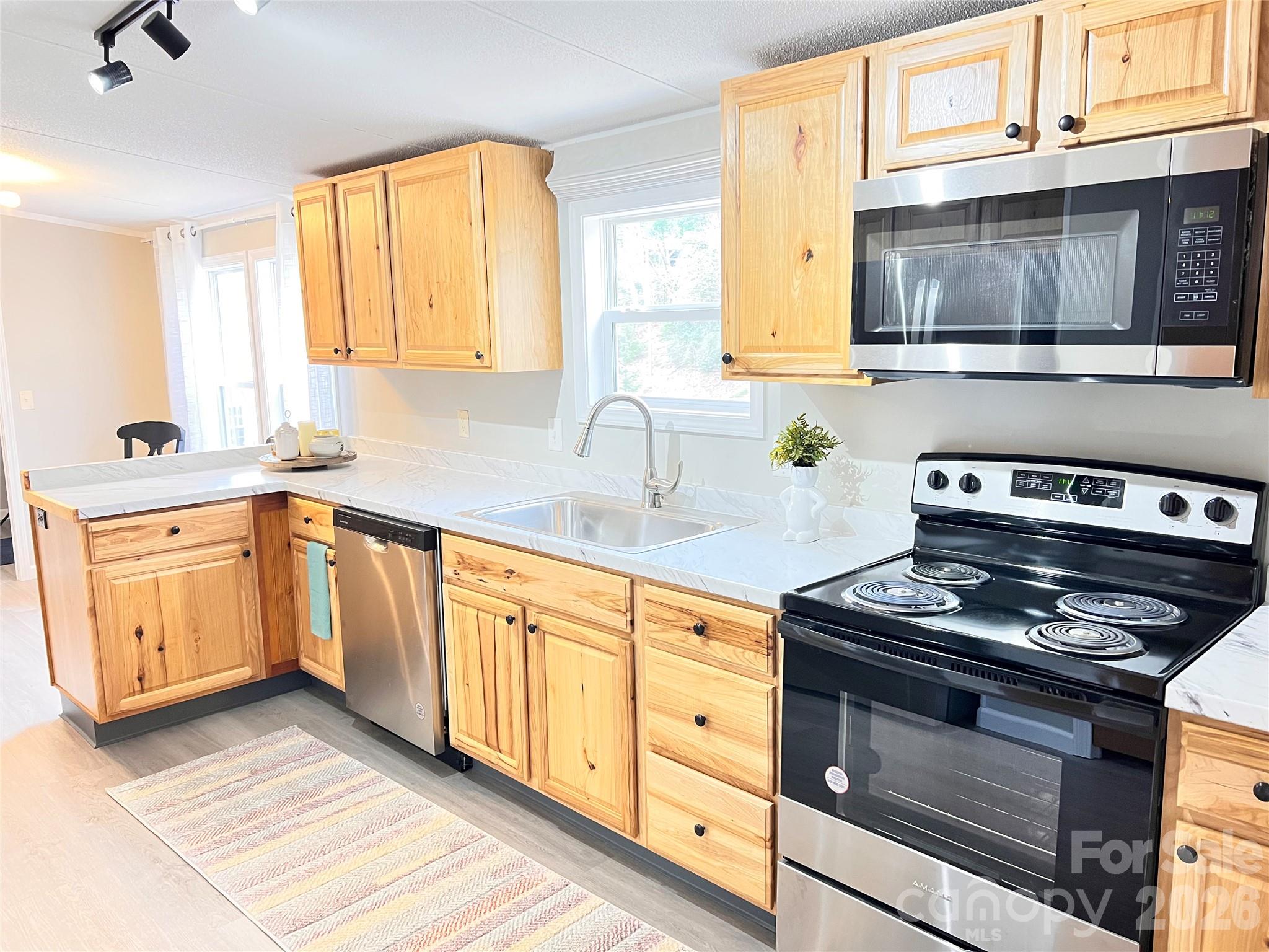 25 Overbrook Drive Saluda, NC 28773 - Photo 3 of 42 a kitchen with granite countertop a stove a sink and wooden cabinets
