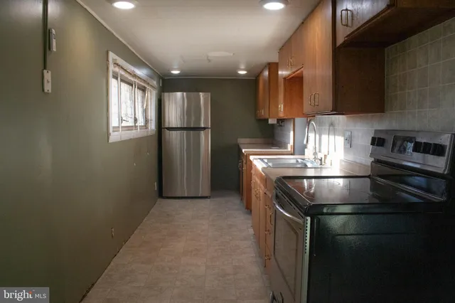 a kitchen with stainless steel appliances granite countertop a sink a stove and a refrigerator