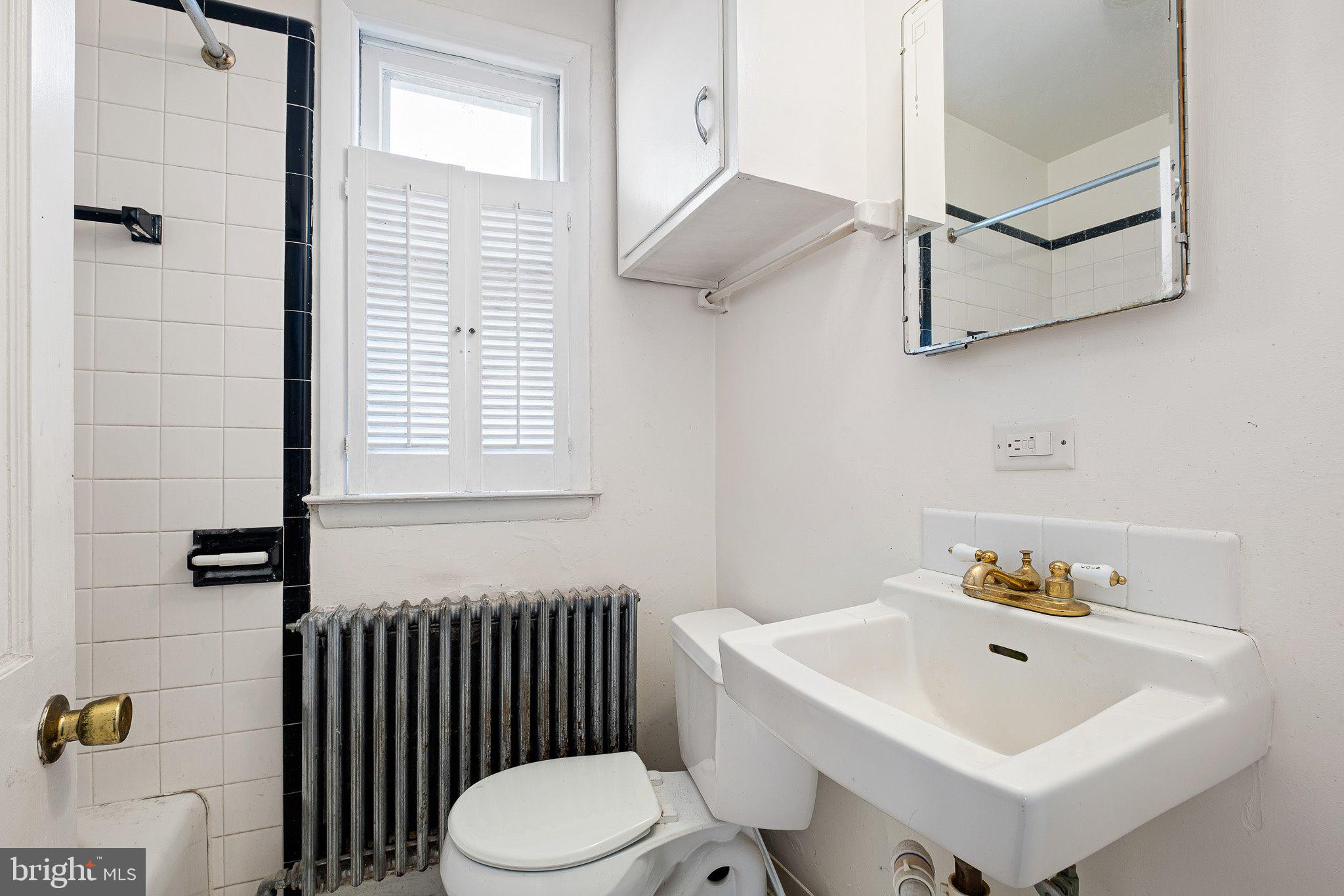 221 Chestnut Street New Castle, DE 19720 - Photo 11 of 25 a bathroom with a sink a toilet and shower curtain