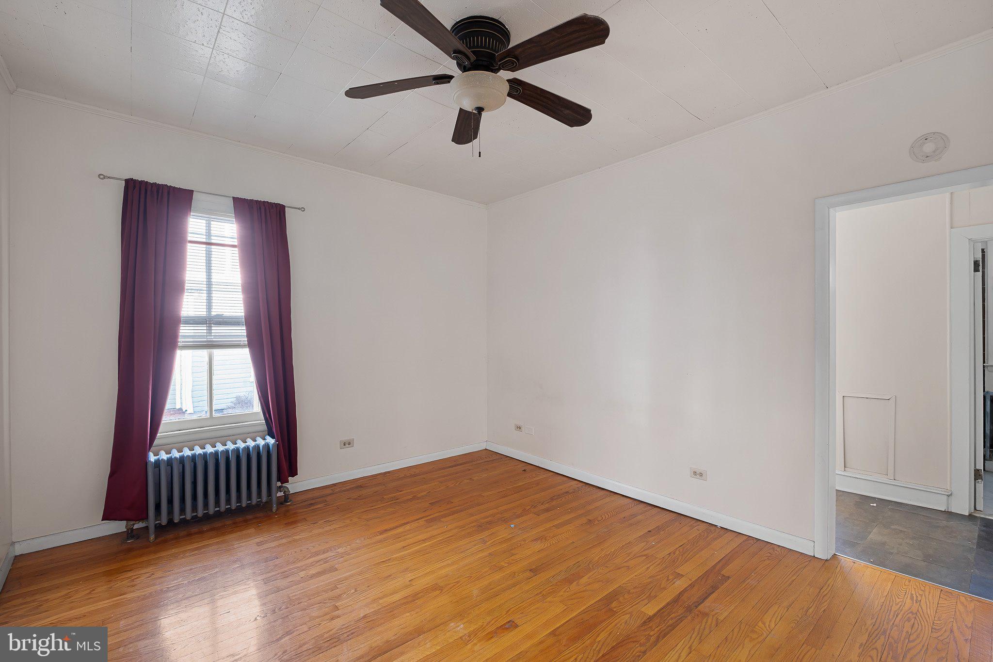 221 Chestnut Street New Castle, DE 19720 - Photo 5 of 25 a view of empty room with wooden floor and fan