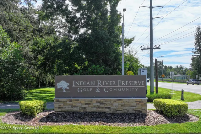 an aerial view of a house with a garden and lake view