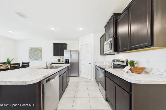 a kitchen with granite countertop stainless steel appliances a sink stove and refrigerator