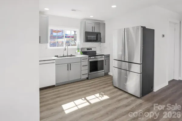a kitchen with stainless steel appliances granite countertop a refrigerator stove a sink and a microwave