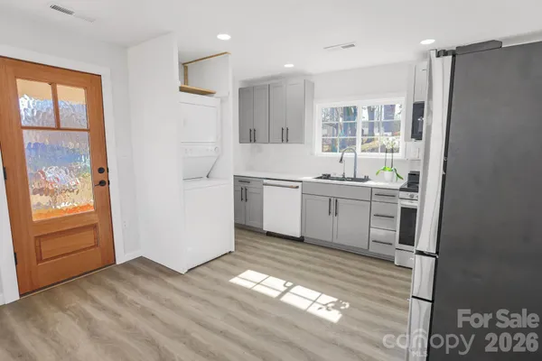 a view of a kitchen with wooden floor and electronic appliances