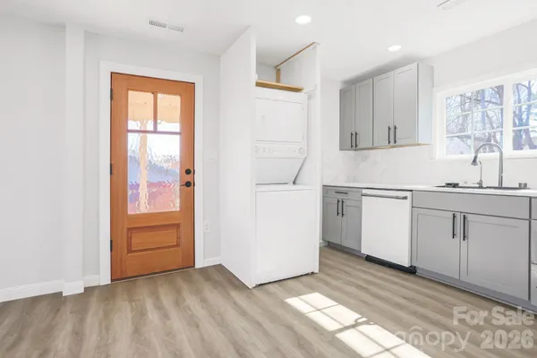 a view of a kitchen with wooden floor and electronic appliances