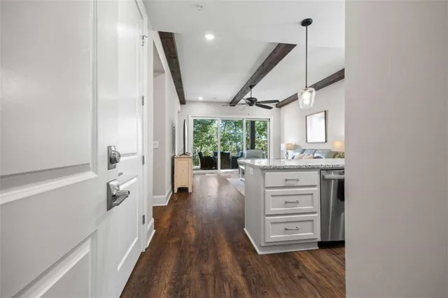 a kitchen with granite countertop a stove cabinets and wooden floor
