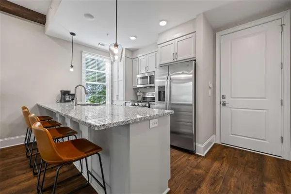 a kitchen with a refrigerator and white cabinets