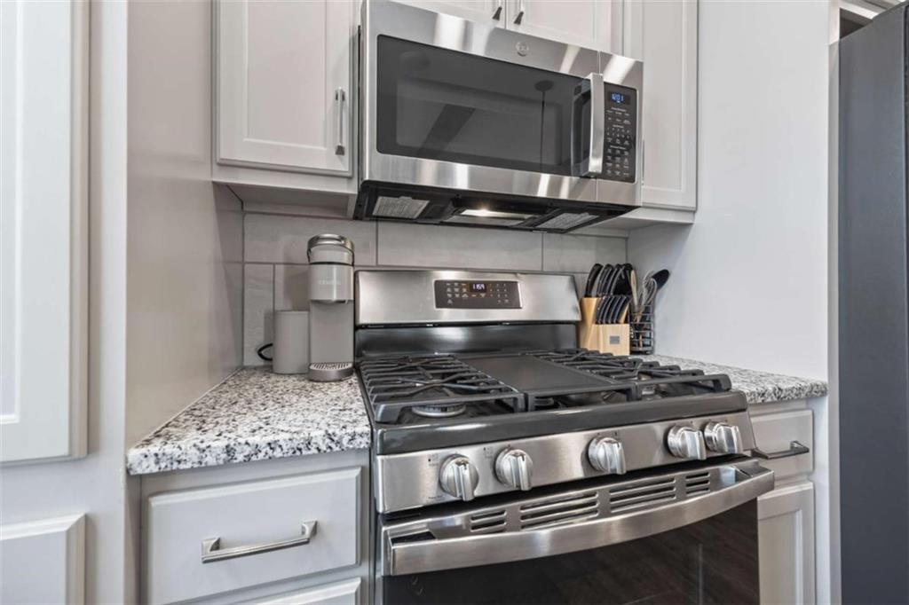 15 Cottage Lane, Unit 102 Toccoa, GA 30577 - Photo 22 of 40 a kitchen with stainless steel appliances granite countertop a stove and a microwave