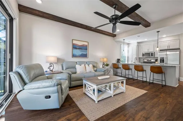 a living room with furniture a flat screen tv and a floor to ceiling window