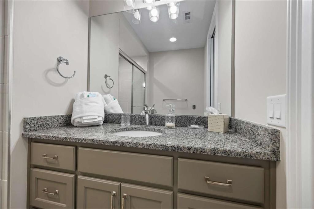 15 Cottage Lane, Unit 102 Toccoa, GA 30577 - Photo 33 of 40 a bathroom with a granite countertop sink and a mirror