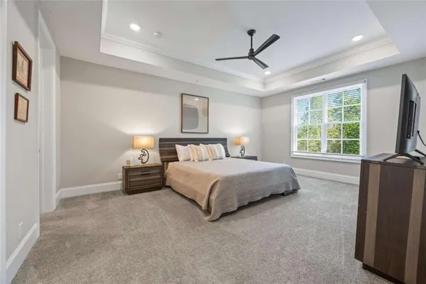 a spacious bedroom with a bed and a lamp