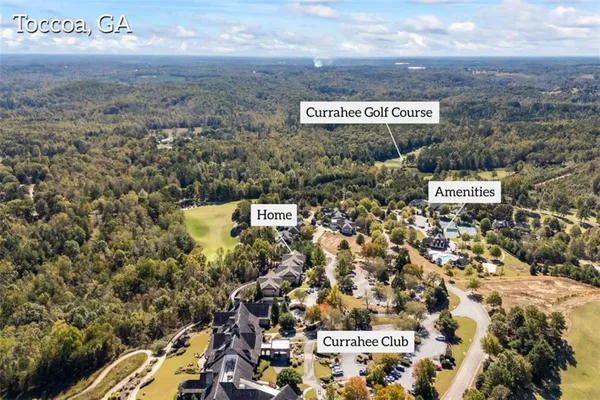 an aerial view of a house with a yard and parking