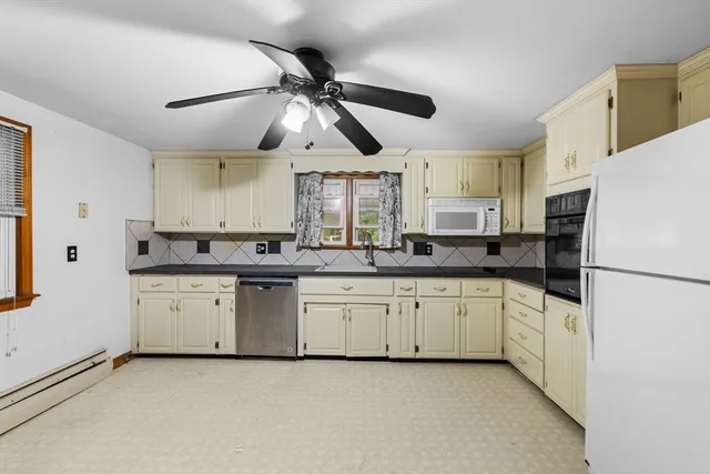 a kitchen with stainless steel appliances a refrigerator a sink and white cabinets