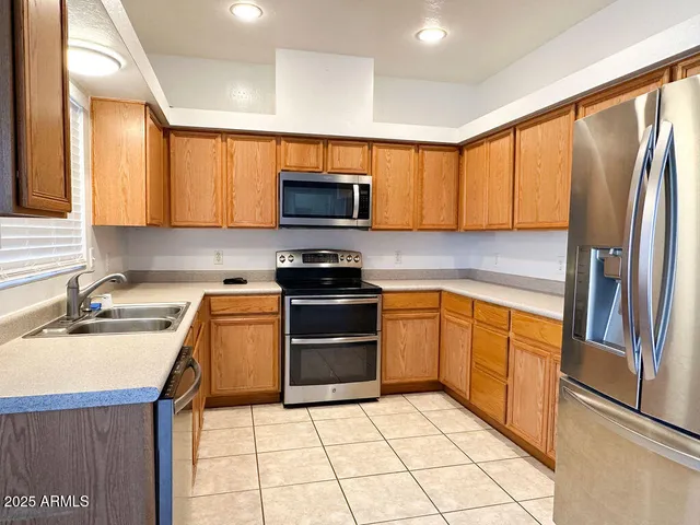 a kitchen with stainless steel appliances granite countertop a refrigerator stove top oven a sink and dishwasher