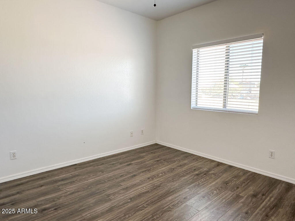 15220 Padres Road Arizona City, AZ 85123 - Photo 5 of 16 an empty room with wooden floor and windows