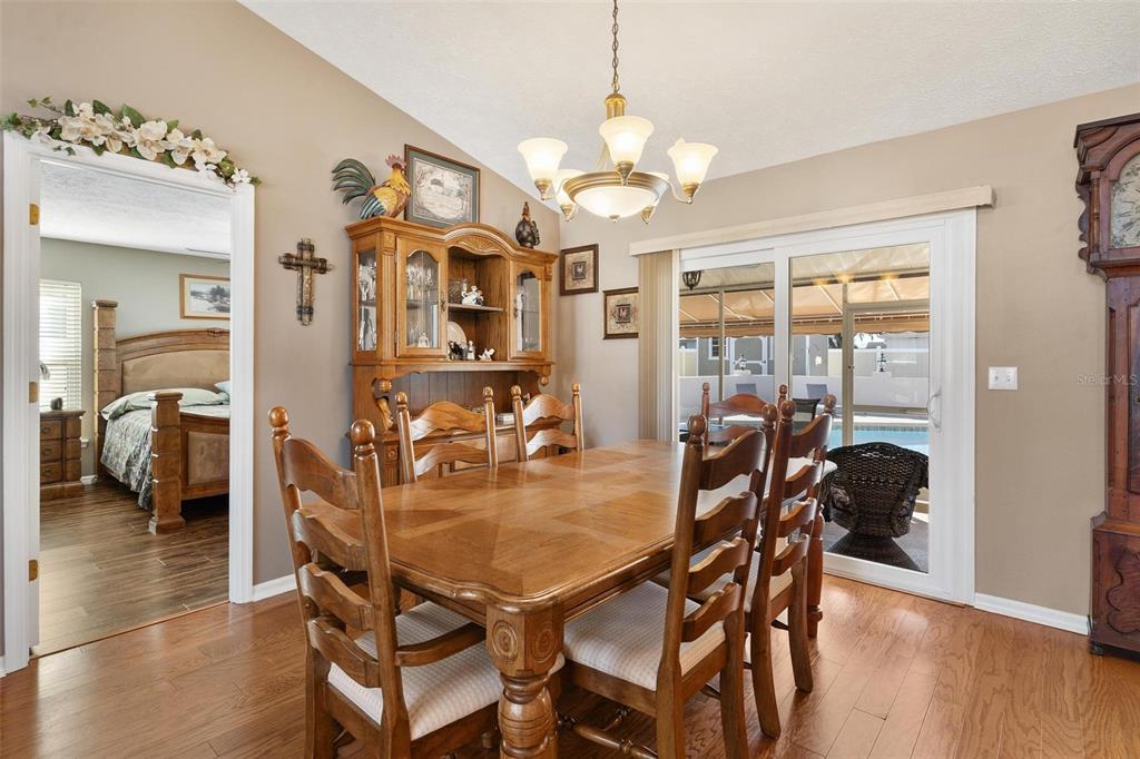 450 Northeast 55th Street Ocala, FL 34479 - Photo 13 of 68 a dining room with wooden floor a chandelier a glass table and chairs
