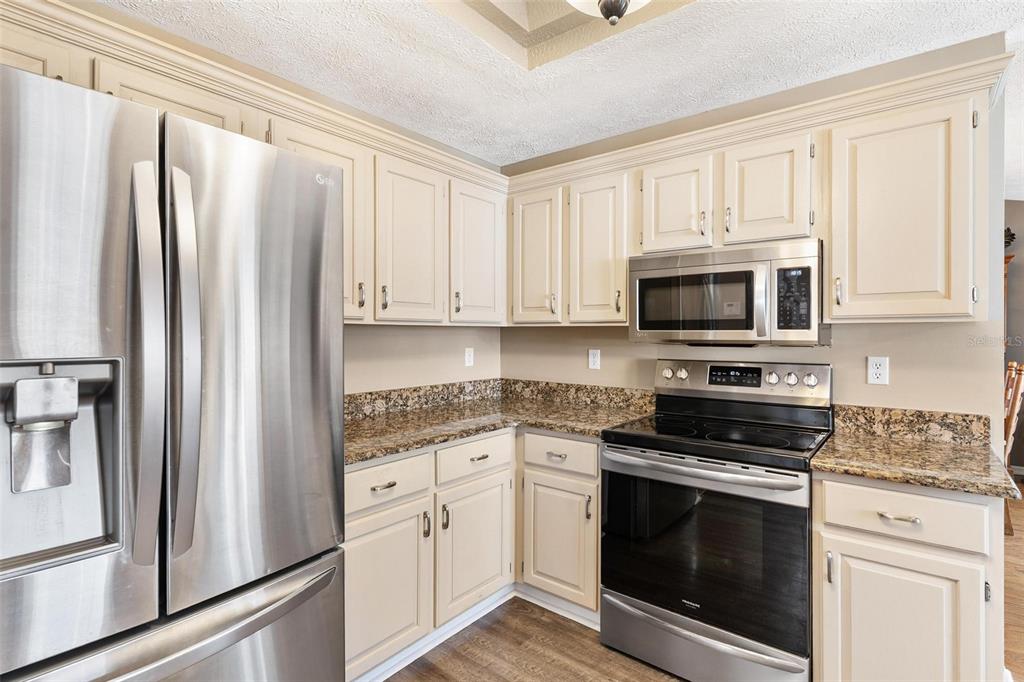 450 Northeast 55th Street Ocala, FL 34479 - Photo 17 of 68 a kitchen with stainless steel appliances white cabinets and a stove top oven