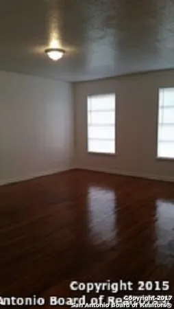 a view of wooden floor and windows in a room