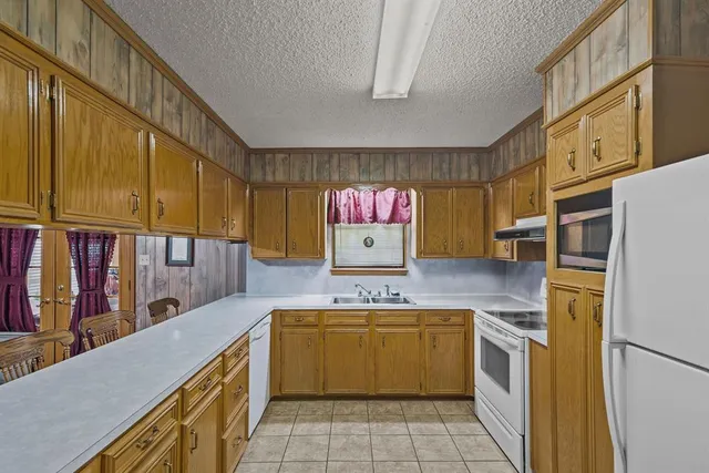 a kitchen that has a sink a stove top oven a counter top space and cabinets