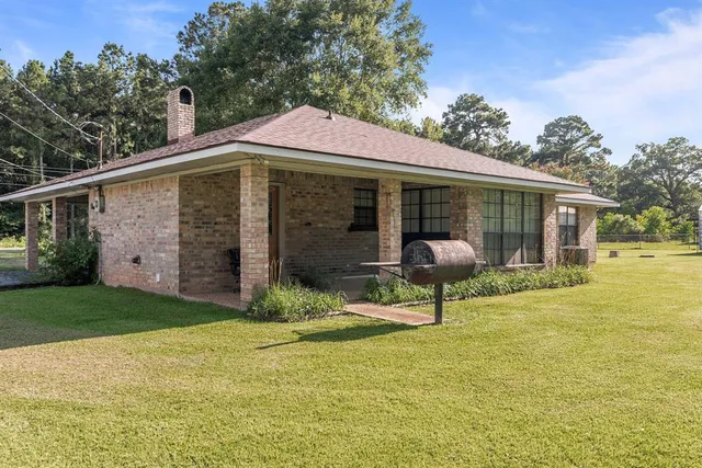 a blue swimming pool with a bench in front of the house