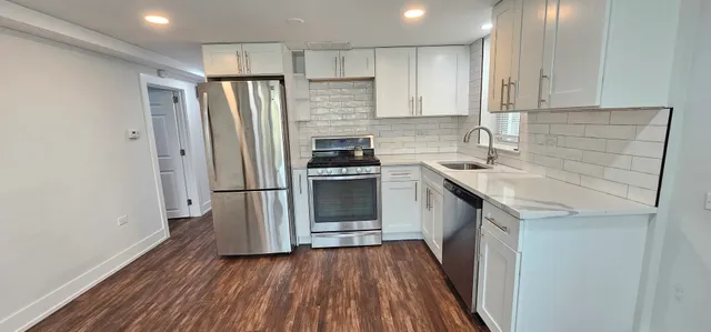 a kitchen with a sink a refrigerator and cabinets