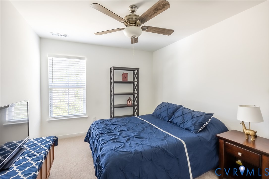 11309 Benton Pointe Way Chester, VA 23831 - Photo 21 of 32 a bedroom with a bed and a chandelier