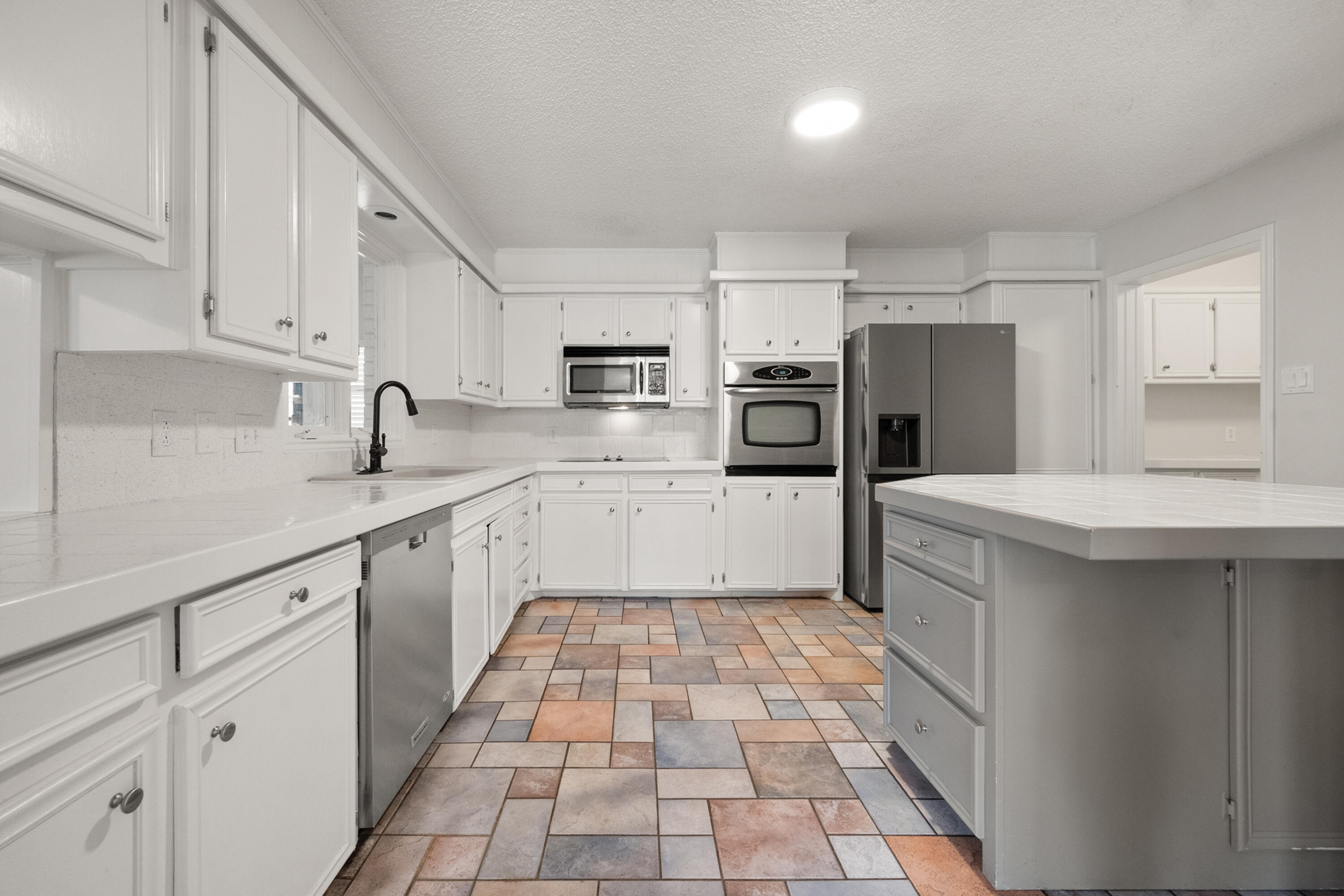 4523 79th Street Lubbock, TX 79424 - Photo 11 of 33 a kitchen with a sink a refrigerator and cabinets