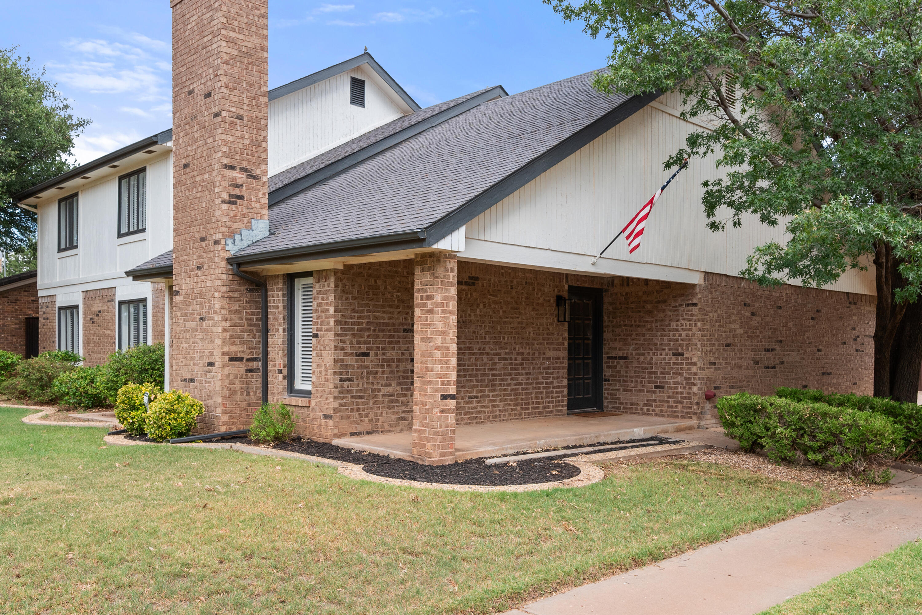 4523 79th Street Lubbock, TX 79424 - Photo 2 of 33 a view of a white house with large windows and a small yard