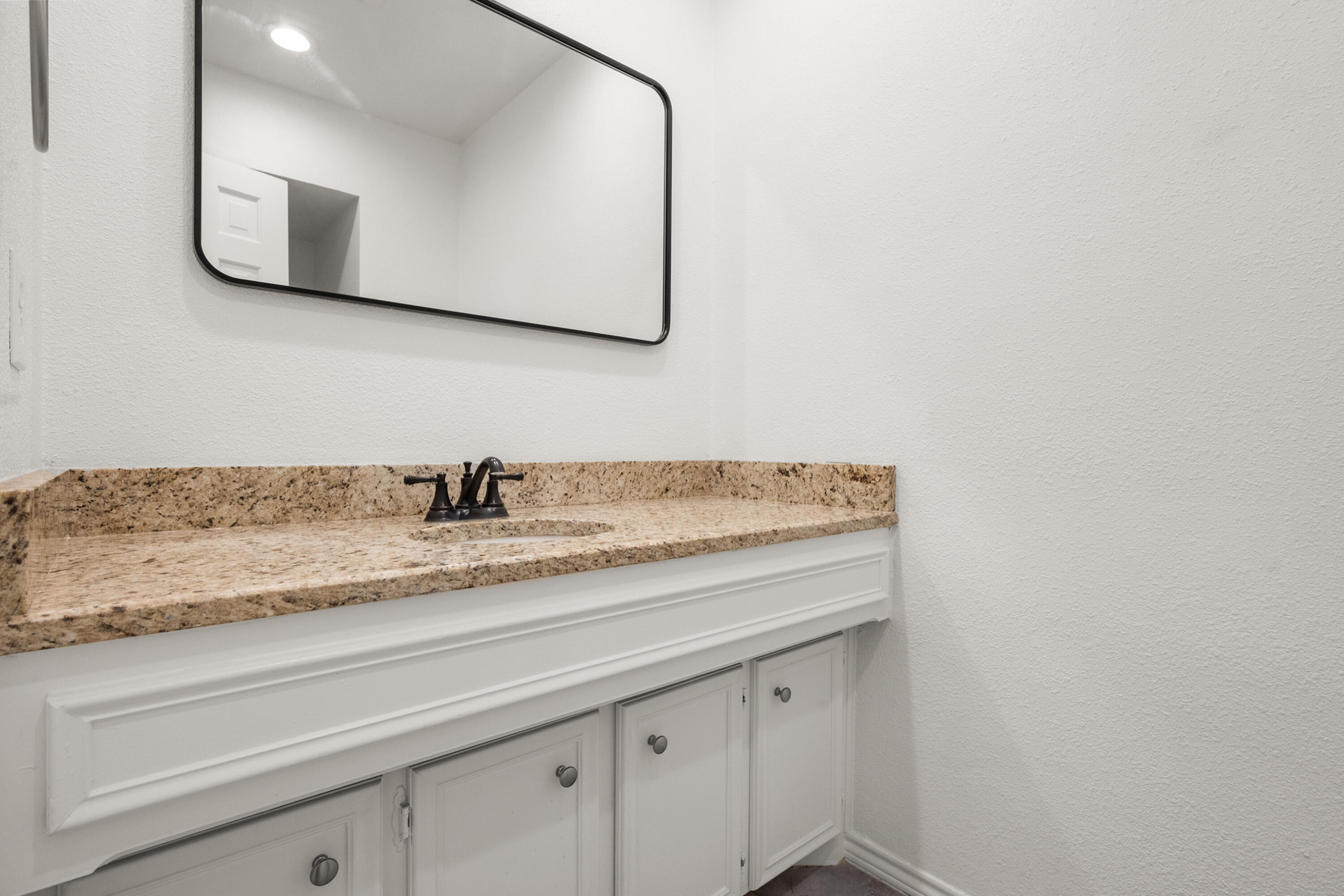 4523 79th Street Lubbock, TX 79424 - Photo 8 of 33 a bathroom with a granite countertop sink and a mirror