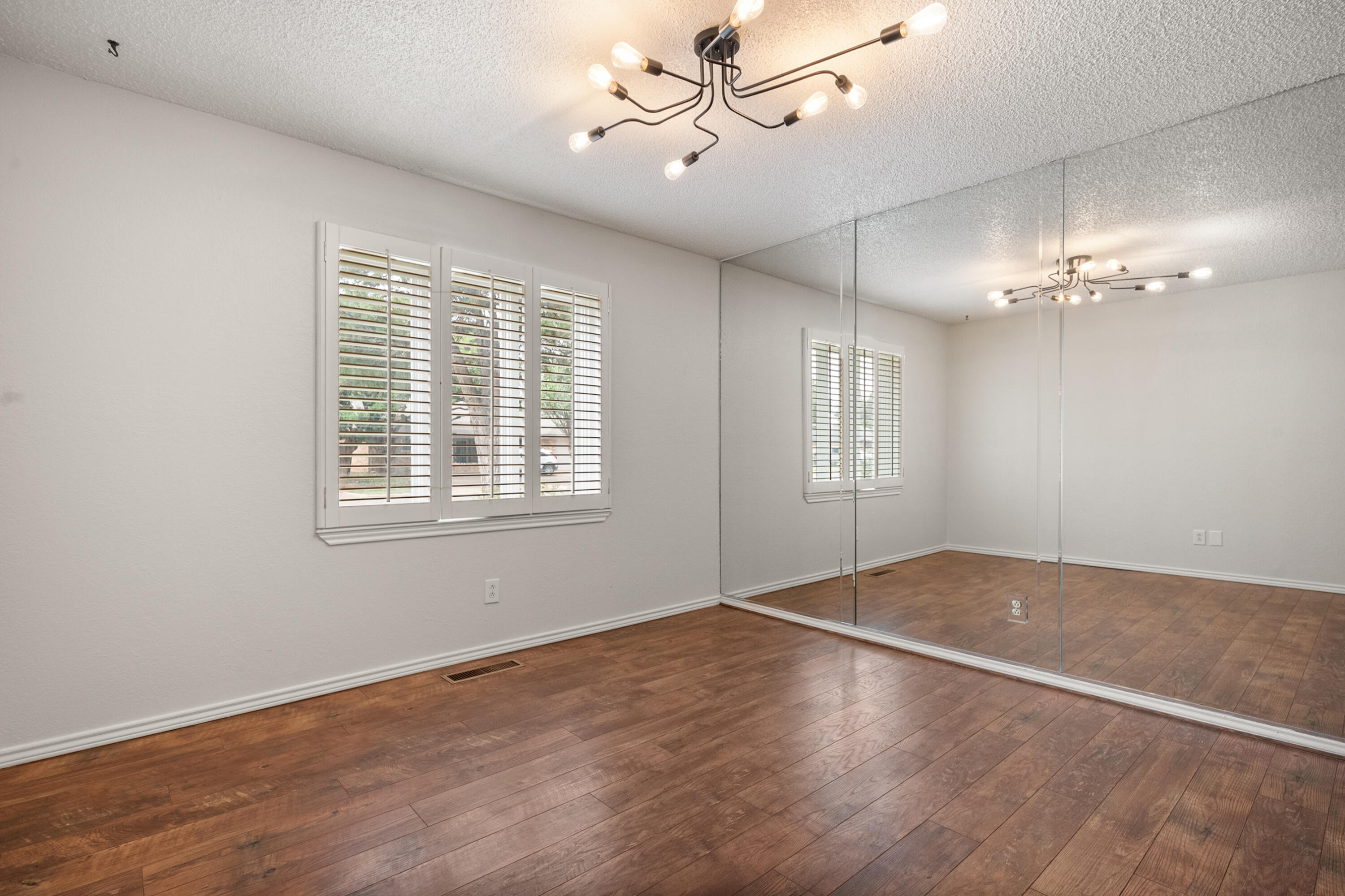 4523 79th Street Lubbock, TX 79424 - Photo 9 of 33 an empty room with wooden floor fan and windows
