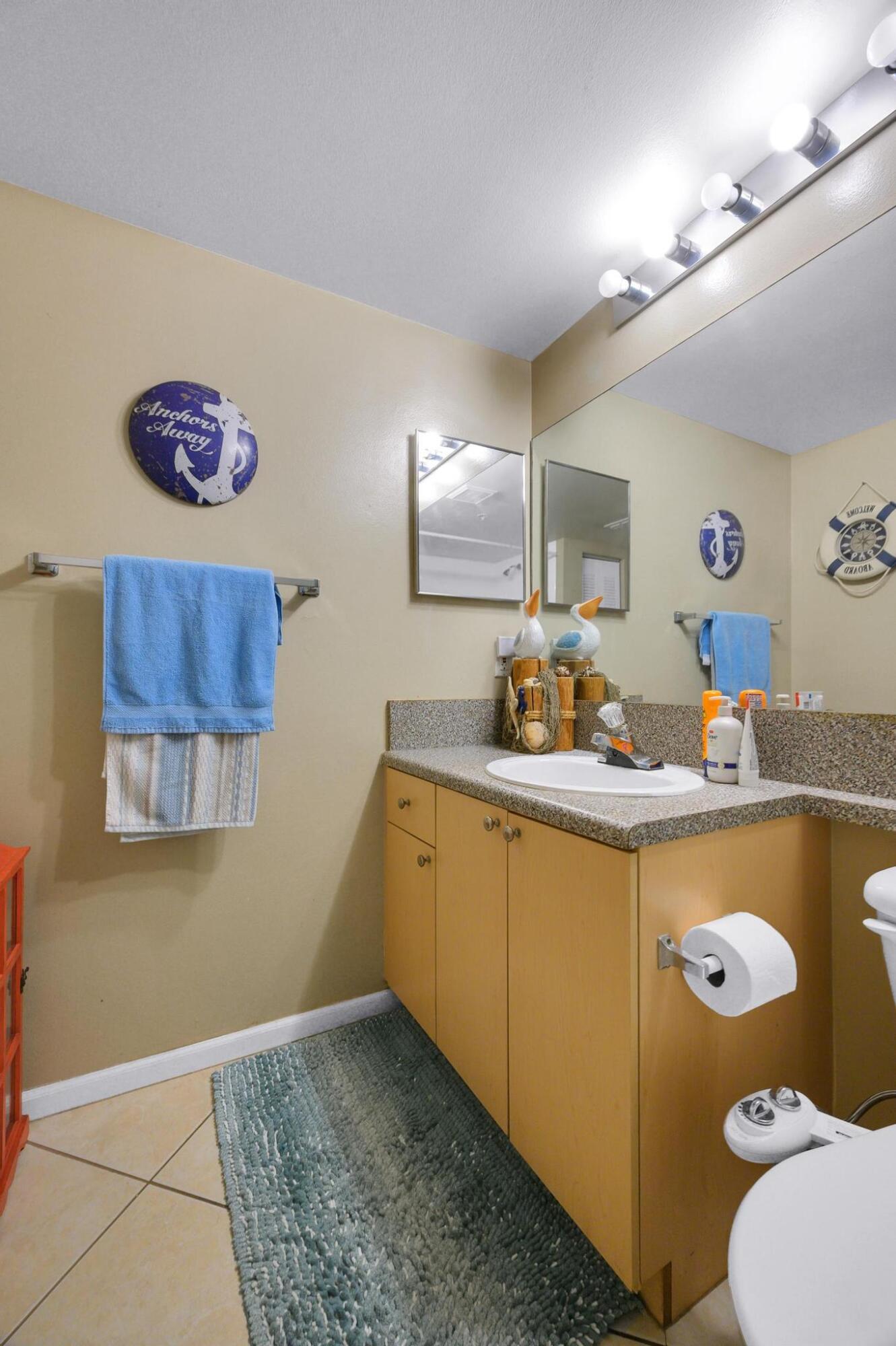 3670 Northwest Adriatic Lane Jensen Beach, FL 34957 - Photo 12 of 26 a spacious bathroom with a granite countertop sink and a mirror
