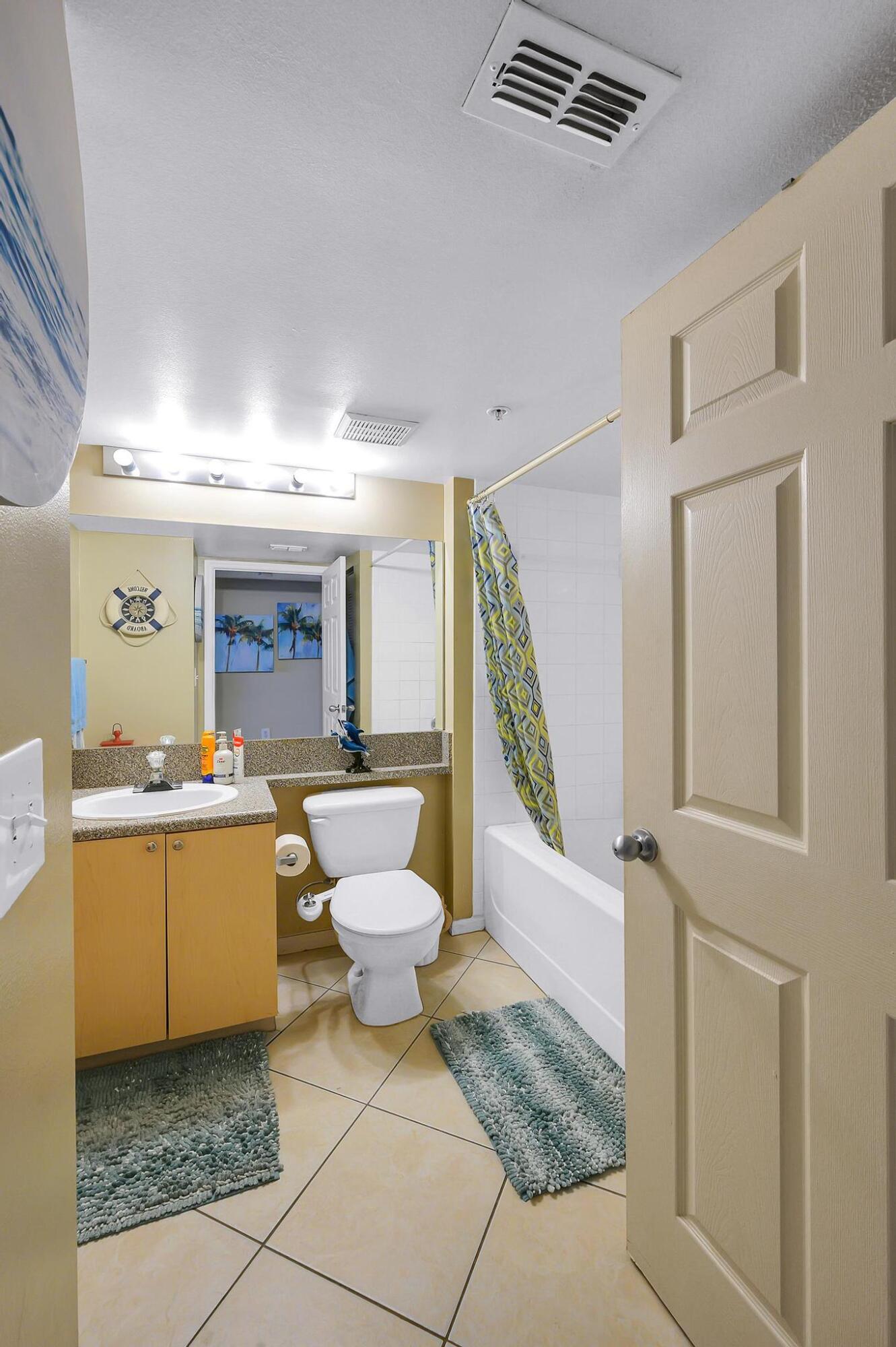 3670 Northwest Adriatic Lane Jensen Beach, FL 34957 - Photo 13 of 26 a bathroom with a toilet a sink and a mirror