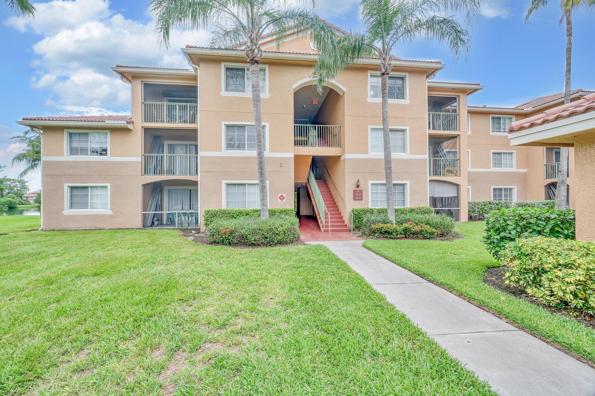 3670 Northwest Adriatic Lane Jensen Beach, FL 34957 - Photo 2 of 26 a front view of a residential houses with yard and green space