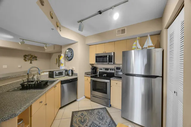 a kitchen with a refrigerator a stove a sink a microwave and cabinets