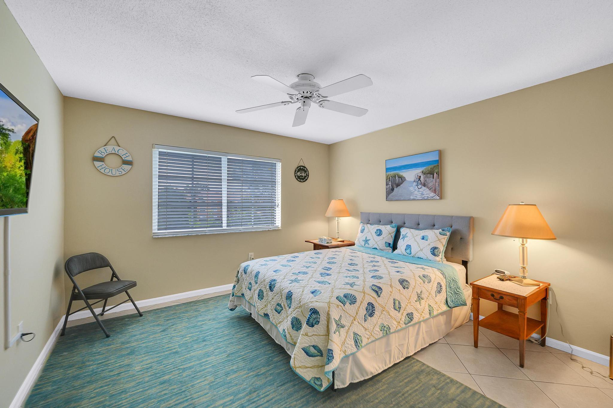 3670 Northwest Adriatic Lane Jensen Beach, FL 34957 - Photo 9 of 26 a bedroom with a bed a chair and a window